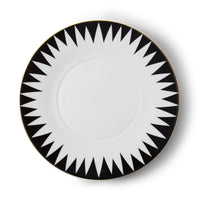 The Punk Dinnerware by Molecot features a round white Limoges porcelain plate with a bold black geometric sunburst rim and thin gold trim—a striking piece of modern tableware.