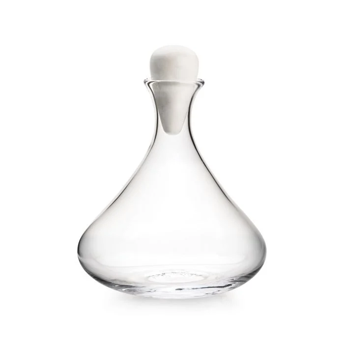 The Simon Pearce Vintner Wine Decanter With Marble Stopper features clear handmade glass with a wide, rounded base and narrow neck, topped by a sleek marble stopper, shown against a plain white background.