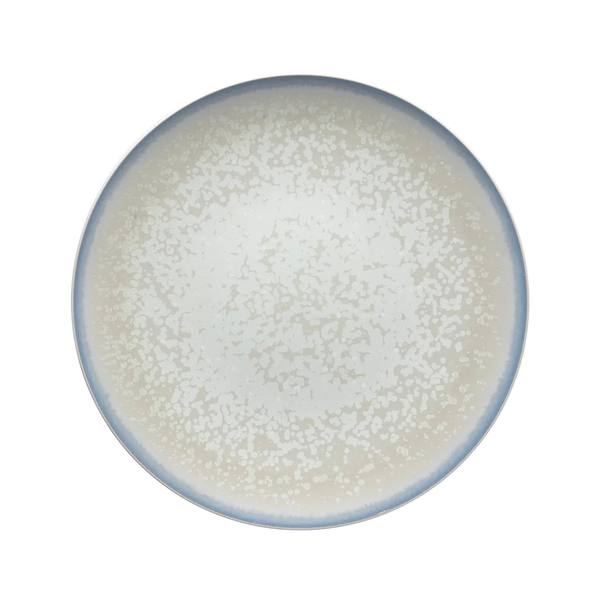 The Song Dinnerware Perle - Agoro plate by Jaune De Chrome is a round, high-fired porcelain piece with a speckled white and gray surface and blue-gray rim, shown from above on white—ideal for an elegant table setting.