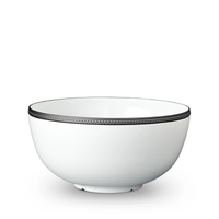 The Soie Tressée Black Dinnerware by L'Objet is a white ceramic bowl featuring an elegant textured black trim around the rim, evoking luxury porcelain, set against a white background.