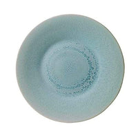 The Vuelta Atoll plate by Jars - Rosenthal is a round, light blue ceramic dish with a textured, darker circular pattern and speckled center—ideal for anyone seeking microwave-safe modern dinnerware.