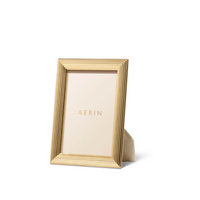 The Aerin Alessio Frame features a gold reeded design and stands vertically, displaying an AERIN-branded placeholder card against a plain white background.