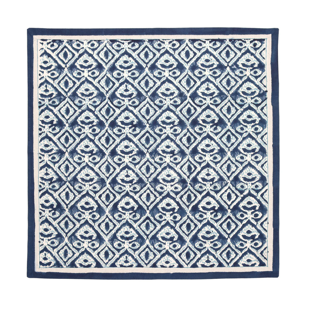 The Kim Seybert Alfresco Napkin Navy & Blue Set of 4 features a square cotton design with blue and white geometric and floral patterns, inspired by Indian block printing, and finished with a solid blue border.