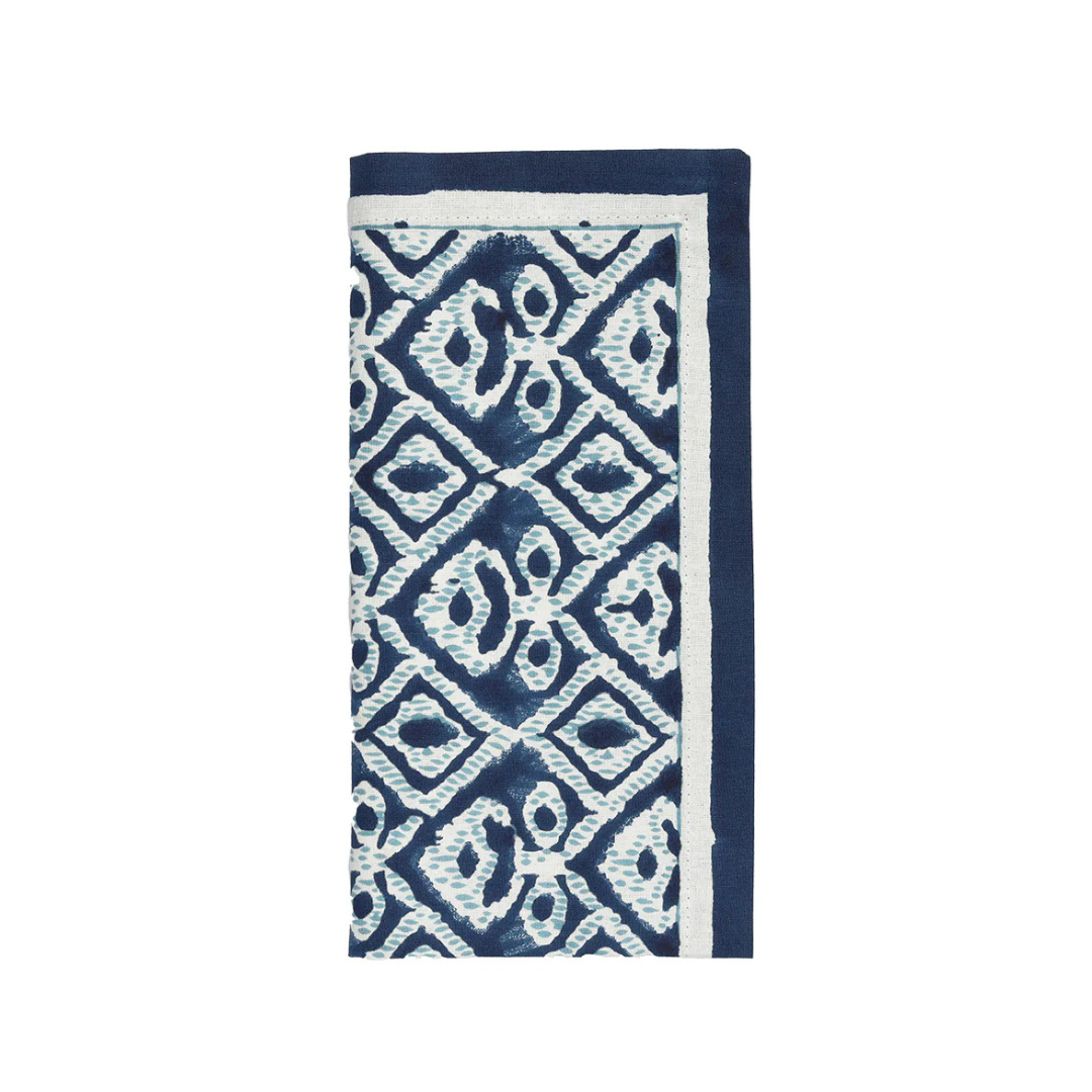 The Kim Seybert Alfresco Napkin Navy & Blue Set of 4 features folded cotton napkins with a blue and white geometric diamond pattern and a solid blue border, inspired by traditional Indian block printing—ideal for alfresco dining.