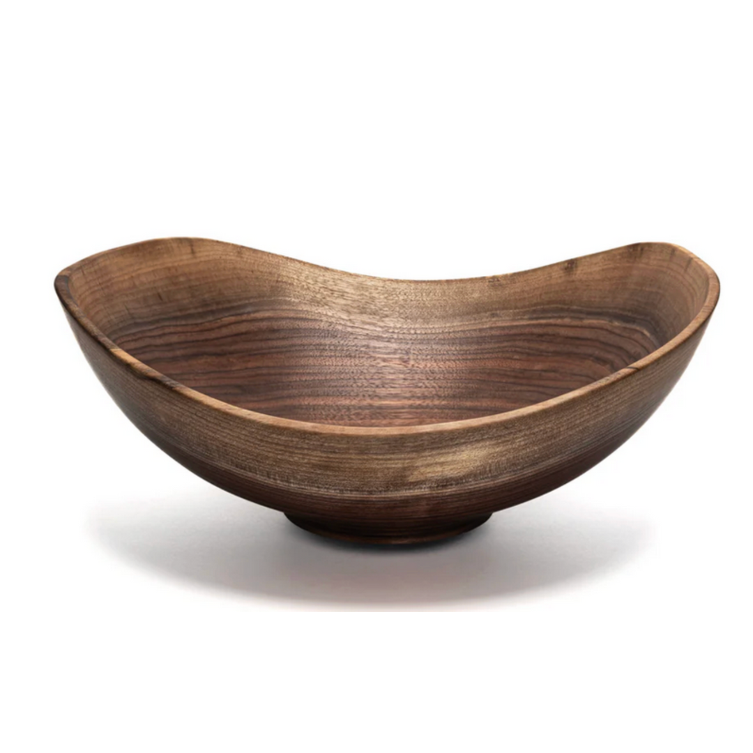 The Andrew Pearce Live Edge Wood Bowl Walnut - Oval Medium is handcrafted, featuring an organic, asymmetrical shape and a smooth, polished finish that highlights the natural walnut grain in varying brown tones.