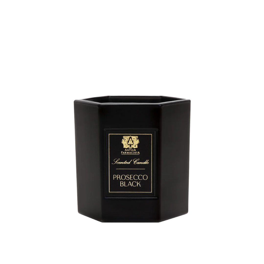A black, hexagonal Prosecco Black Candle by Antica Farmacista/Harper features a gold and black label with a crest, crafted from soy-paraffin wax, shown against a white background.
