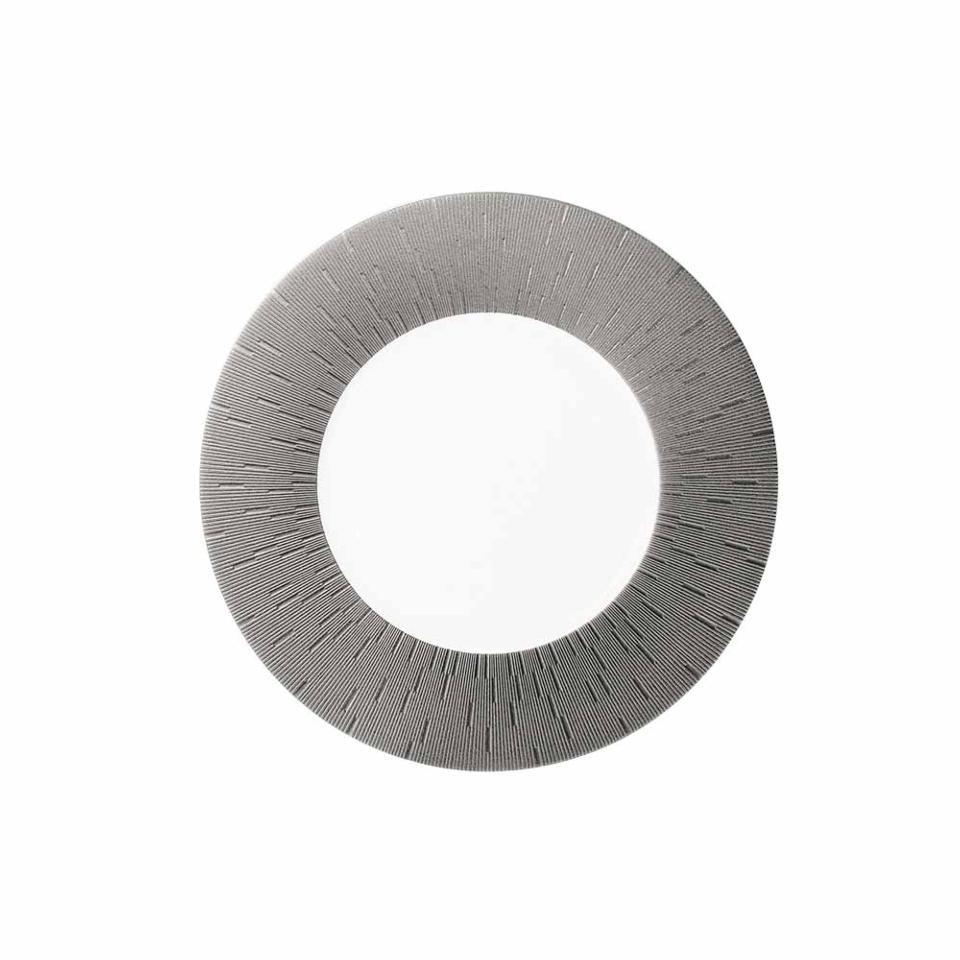 A circular metallic object with a hollow center and fine, radiating lines—reflecting the timeless elegance of Haviland’s Anthracite Infini Dinnerware Grey.
