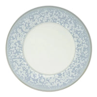The Song Ocean Dinnerware by Jaune De Chrome is a round ceramic plate with a wide light blue border featuring a white speckled pattern and a solid white center.