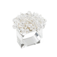 The Kim Seybert Aster Napkin Ring Set of 4 features clear, rectangular glass rings topped with transparent faceted bead clusters, adding a sparkling floral accent to your table décor.