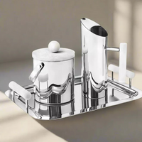 A modern silver tray holds the Godinger Azure Pitcher - White, a sleek handmade stainless steel barware piece with white marble accents, set on a neutral background with soft shadows.