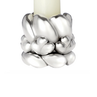 The Babylone Candlestick Holder by Christofle features a sleek silver-plated design with heart-shaped accents at the base, elegantly holding an ivory candle—perfect for sophisticated interior decoration.