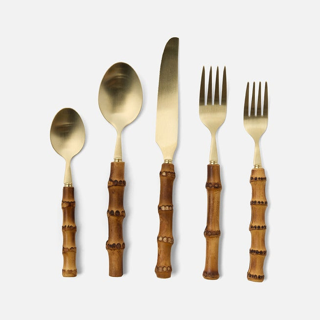 The Blue Pheasant Zoya Bamboo Flatware 5 Piece Setting in matte gold features bamboo-style handles and includes a spoon, soup spoon, knife, dinner fork, and salad fork—ideal for an elegant table setting.