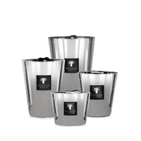 Four reflective silver candles of varying heights from Baobab’s Les Exclusives Platinum collection, each with a black branded label, are arranged together on a white background to create a warm and inviting atmosphere.