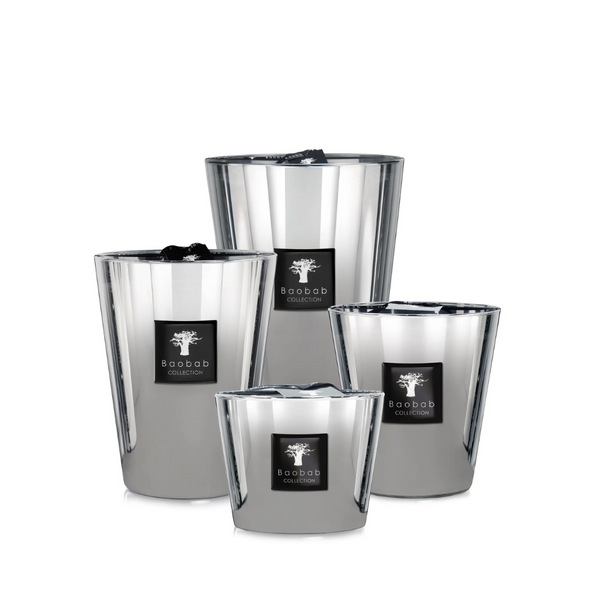 Four reflective silver candles of varying heights from Baobab’s Les Exclusives Platinum collection, each with a black branded label, are arranged together on a white background to create a warm and inviting atmosphere.