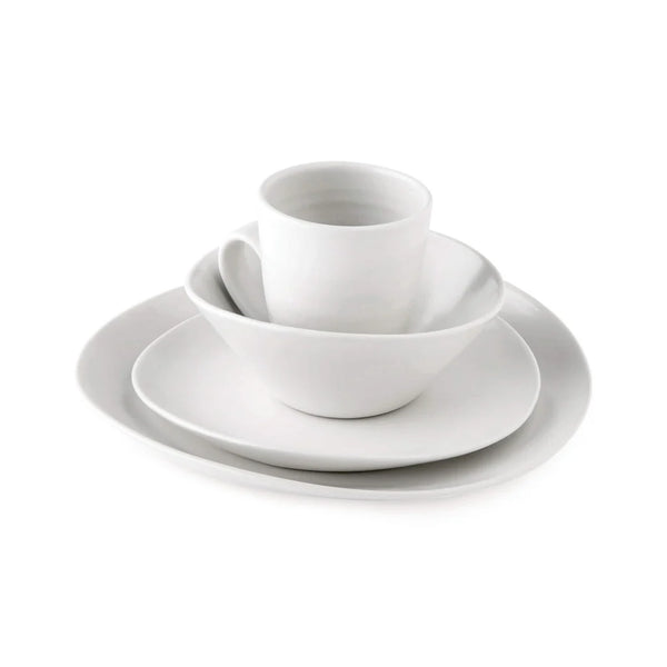 The Barre Dinnerware Alabaster set by Simon Pearce is a modern white ceramic collection featuring a cup, bowl, salad plate, and dinner plate, all elegantly stacked together against a plain white background.