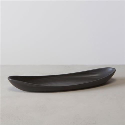 The Simon Pearce Barre Serving Platter in Slate, a sleek and elongated contemporary piece with slightly raised edges, sits on a light gray surface against a plain light background.