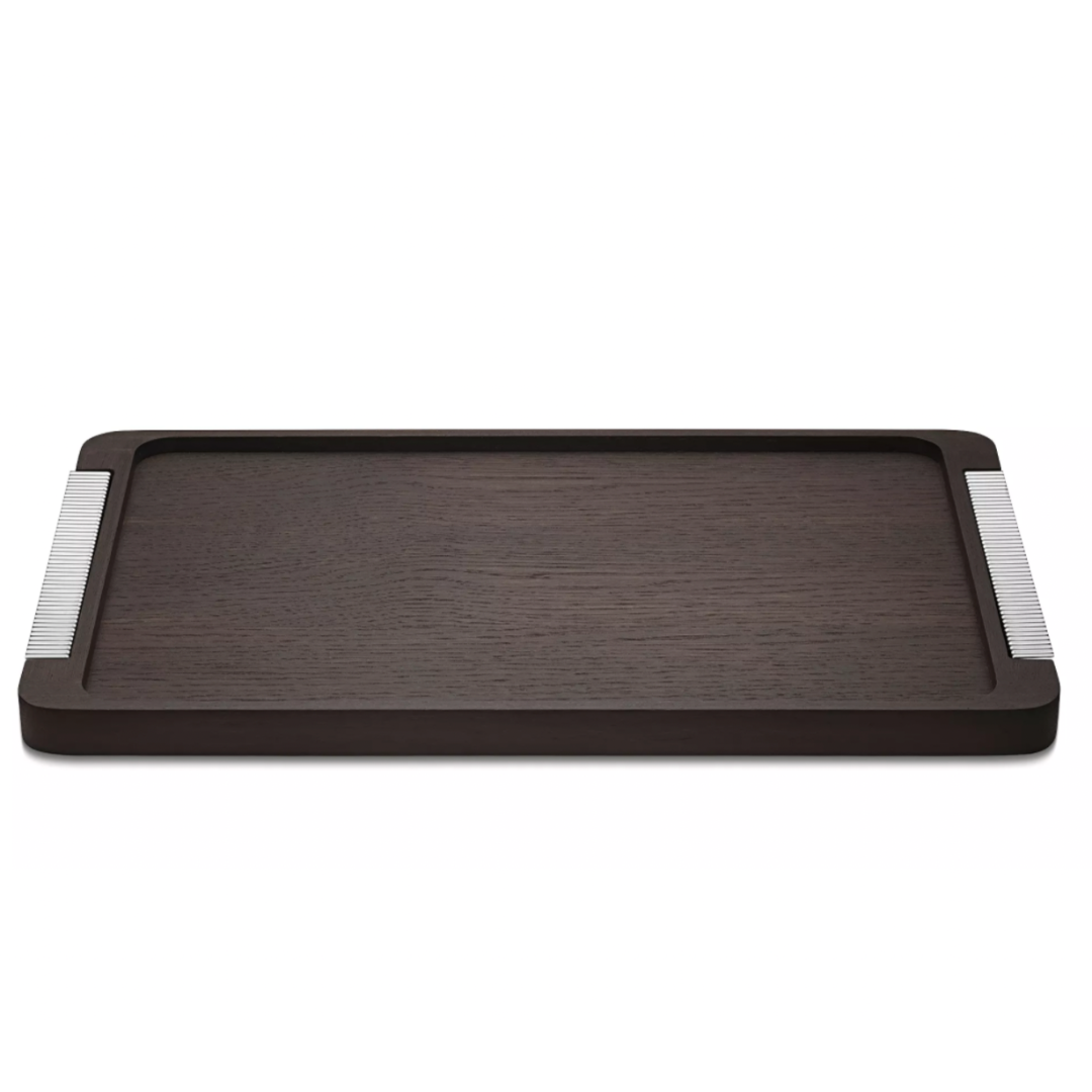 The Georg Jensen Bernadotte Wood Tray is a rectangular smoked oak tray with subtle raised edges and metallic striped handles, bringing elegant Art Deco charm to any setting.