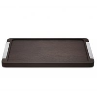The Georg Jensen Bernadotte Wood Tray is a rectangular smoked oak tray with subtle raised edges and metallic striped handles, bringing elegant Art Deco charm to any setting.