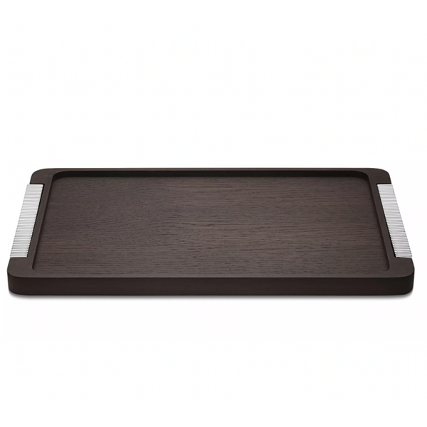 The Georg Jensen Bernadotte Wood Tray is a rectangular smoked oak tray with subtle raised edges and metallic striped handles, bringing elegant Art Deco charm to any setting.