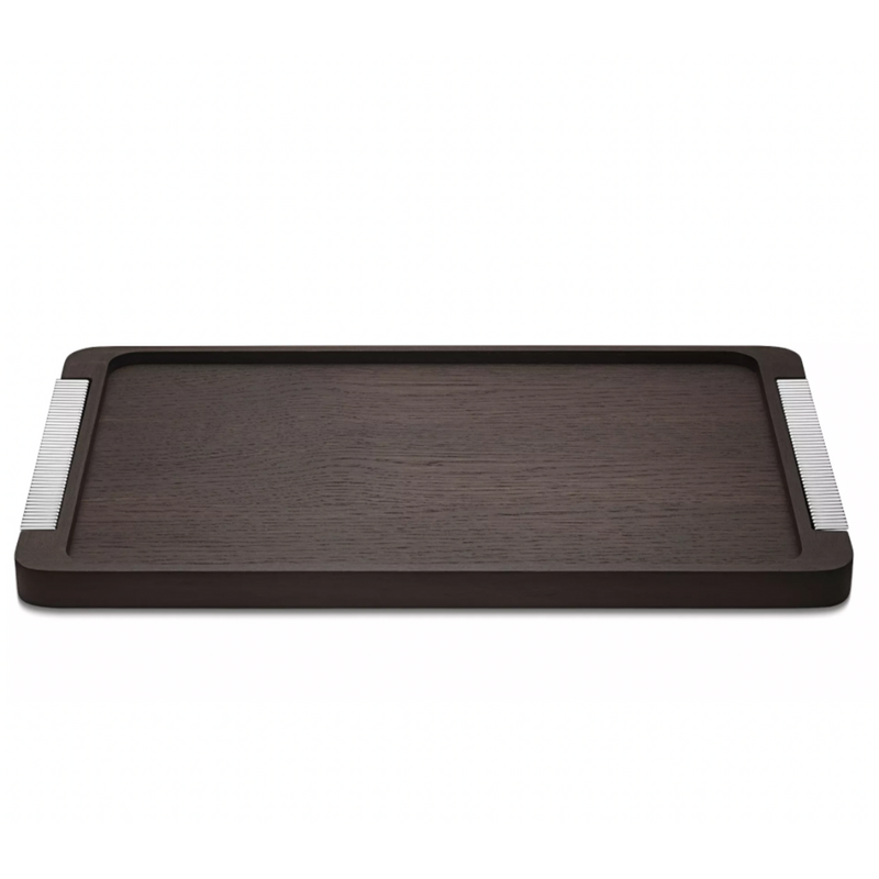 The Georg Jensen Bernadotte Wood Tray is a rectangular smoked oak tray with subtle raised edges and metallic striped handles, bringing elegant Art Deco charm to any setting.