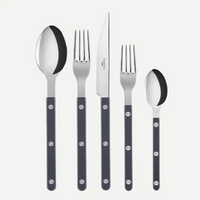 The Sabre Bistrot Solid Flatware 5 Piece Setting - Shiny features stainless steel utensils with black handles—tablespoon, dinner fork, dinner knife, salad fork, and teaspoon—displayed upright in a row on a white background.