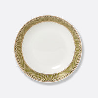 The Augusta Dinnerware plate by Bernardaud is a white ceramic piece with a wide gold and black geometric Art Deco rim, shown from above against a plain light background.