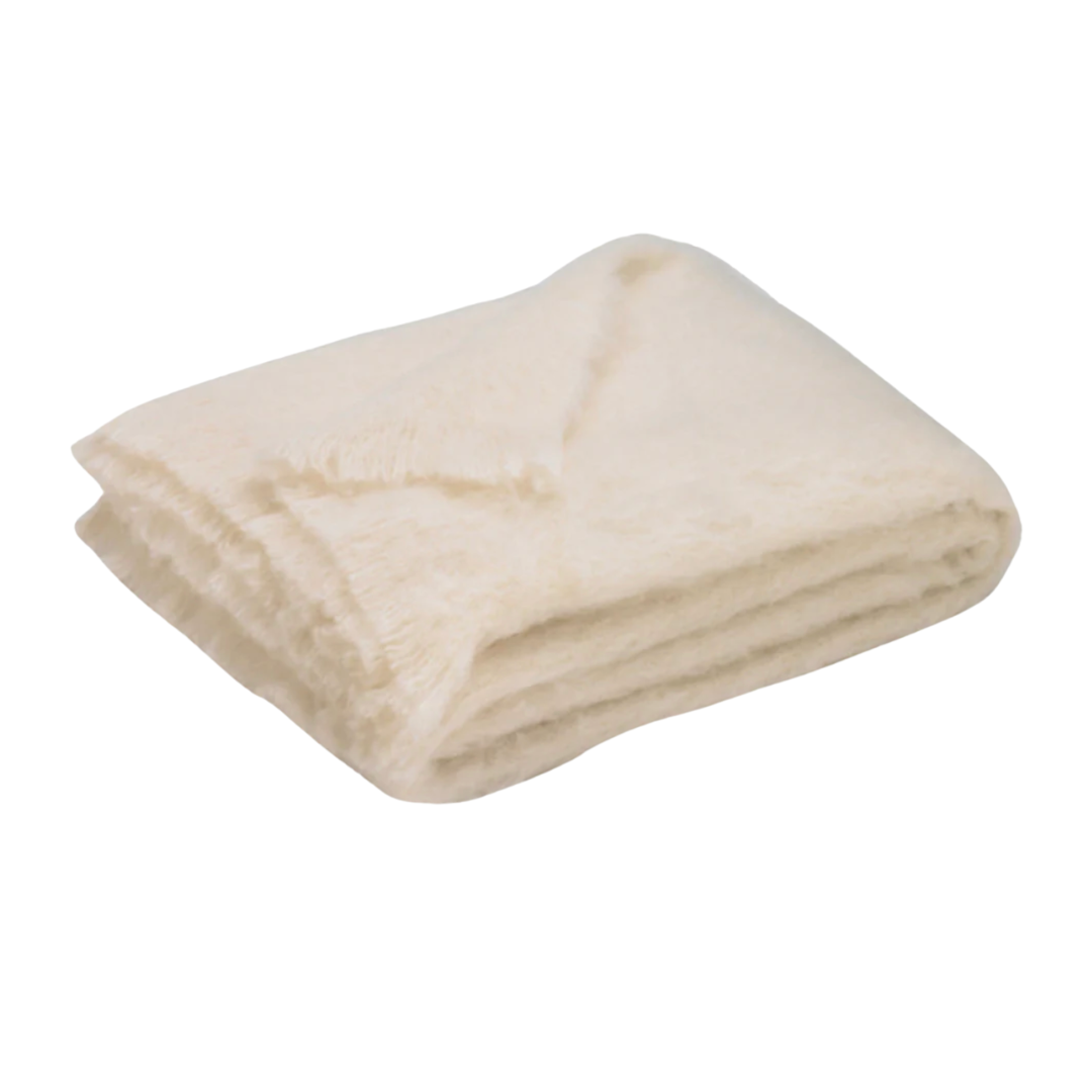A folded, soft Brushed Cream Alpaca Throw by Lands Downunder with a fuzzy texture rests on a white background, offering luxurious warmth and comfort.