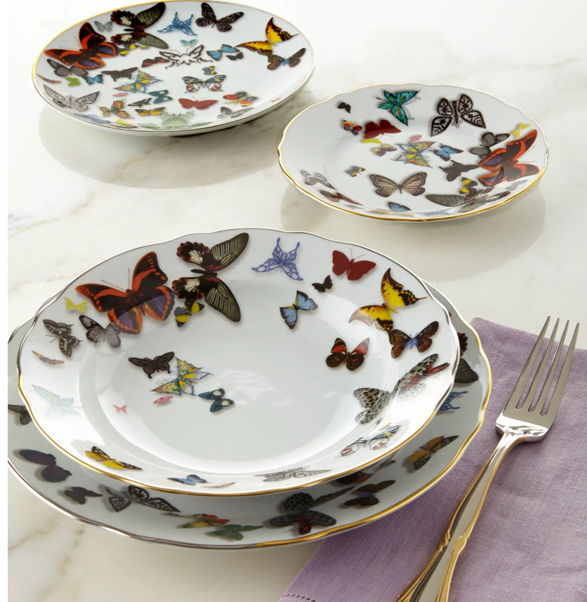 Four white porcelain plates of various sizes from the Vista Alegre Butterfly Parade Dinnerware collection, featuring colorful butterflies and gold rims, arranged on marble—a stunning luxury set perfect for mixing and matching.