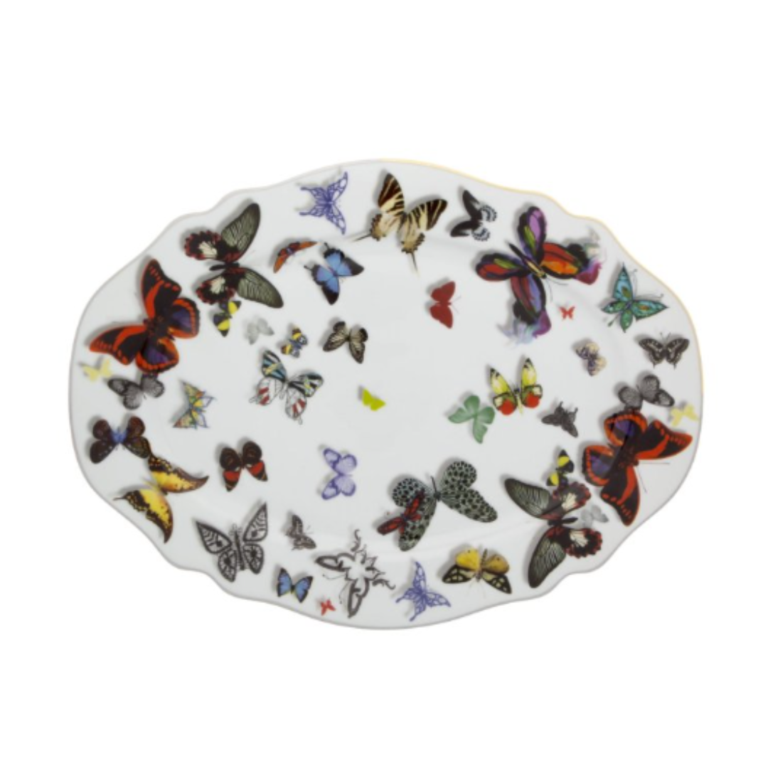 The Vista Alegre Butterfly Parade Dinnerware showcases an oval white plate adorned with vibrant butterfly illustrations in assorted sizes and colors, creating a striking decorative pattern.