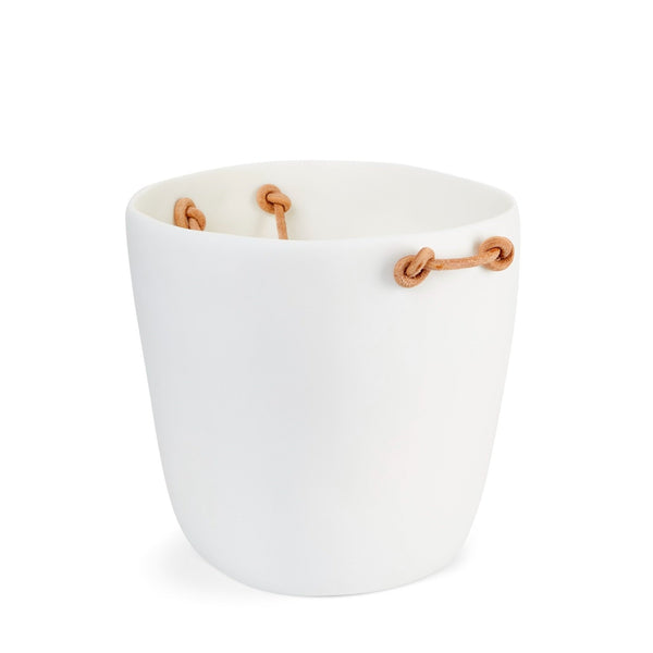 The Tina Frey Champagne Bucket Leather Handle is a white, round ceramic planter with an irregular rim and three tan leather handles looped decoratively through holes near the top.