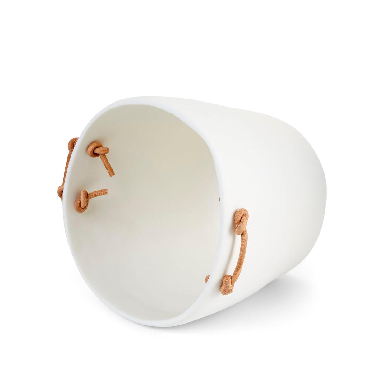 The Tina Frey Champagne Bucket Leather Handle is a white ceramic bucket with four tan leather handles looped through holes near the rim.