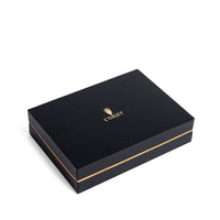 A sleek, rectangular black L'Objet gift box with gold trim and logo sits against a white background—perfect for presenting the Spirale Gold Cocktail Spoons Set of 4 with elegant 24k gold plating.