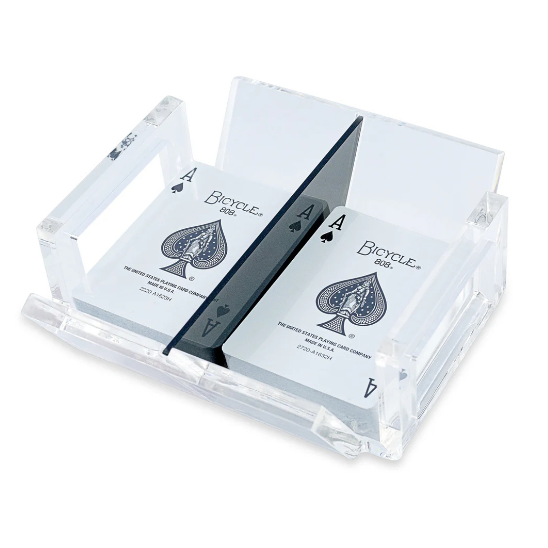 The El Canasta Tray by Luxe Dominoes is a transparent acrylic tray that displays two decks of Bicycle playing cards, each with the Ace of Spades on top and separated by a center divider—an ideal game night accessory.