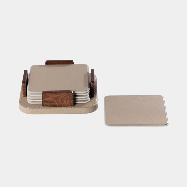 The Zodax Leather & Veneer Coaster Set- Cappuccino features six square earth-tone coasters with rounded edges, stacked in a wood and beige holder, plus one leather coaster displayed separately to the right.