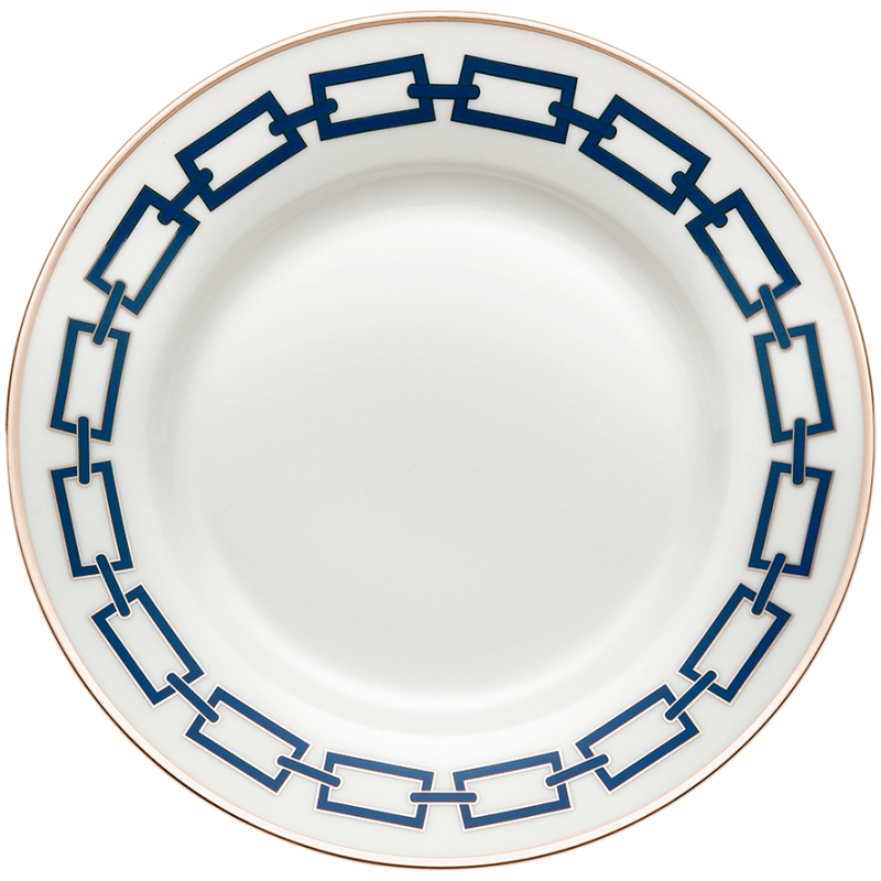 The Ginori 1735 Catene Zaffiro Dinnerware features a white porcelain plate with a navy geometric border and a gold band on the rim, and a plain center, blending modern pattern with classic porcelain elegance.