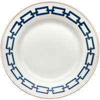 The Ginori 1735 Catene Zaffiro Dinnerware features a white porcelain plate with a navy geometric border and a gold band on the rim, and a plain center, blending modern pattern with classic porcelain elegance.