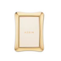 A rectangular Cecile frame by Aerin features a three-dimensional gold design, with the brand name elegantly displayed on a light background against a white backdrop.