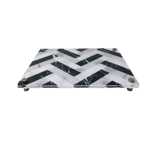 The Eye Candy Raised Serving Board Marble features a black and white chevron pattern and sturdy metal feet—a stylish choice for serving sushi or as a modern challah board.
