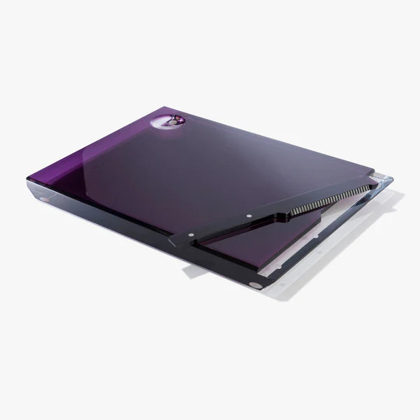 The Apeloig Solid Acrylic Challah Board & Knife features a sleek, rectangular glossy purple surface with a circular cutout handle, a removable black ribbed mat, and is shown on a plain white background.
