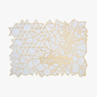 The Apeloig Geometric Challah Cover features intricate gold and white abstract polygonal shapes with Hebrew text near the bottom center, offering a modern and elegant design.