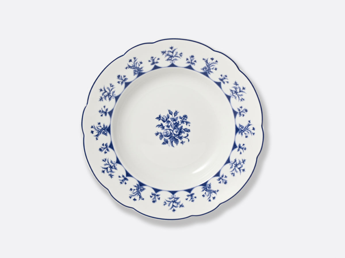 The Bernardaud Chateaubriand Dinnerware dessert plate features a blue floral rim and a blue rose bouquet in the center, making it perfect for serving sweet treats.