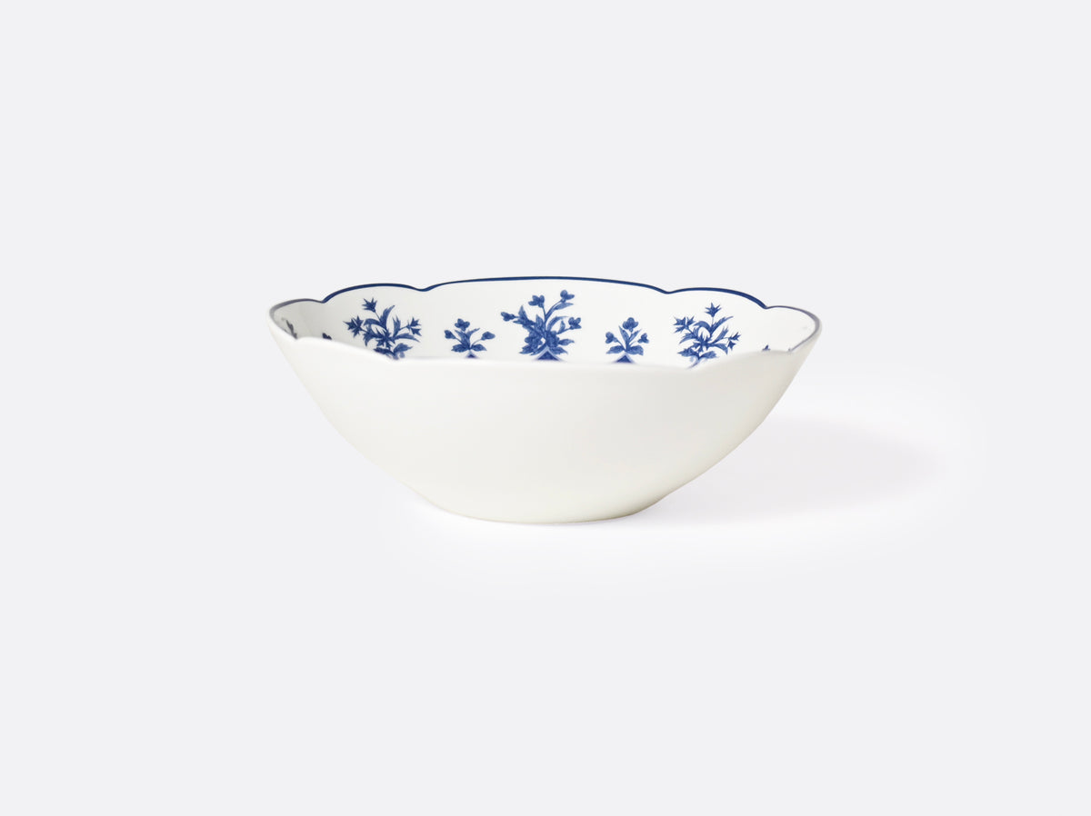 The Chateaubriand Dinnerware by Bernardaud is a white porcelain bowl with a scalloped rim and an elegant blue floral design inside, set against a plain light background.