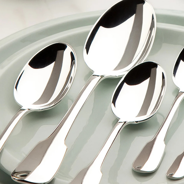 Five polished silver-plated spoons from the Christofle Cluny Flatware 5 Piece Setting are laid out on a light gray plate, their reflective surfaces gleaming against a white background.