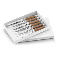 A white box displays the Capdeco Conty Steak Knives Set of 6, each with a shiny stainless steel blade and polished wooden handle. Made in France, this flatware blends elegance and function, arranged side by side inside the open box.