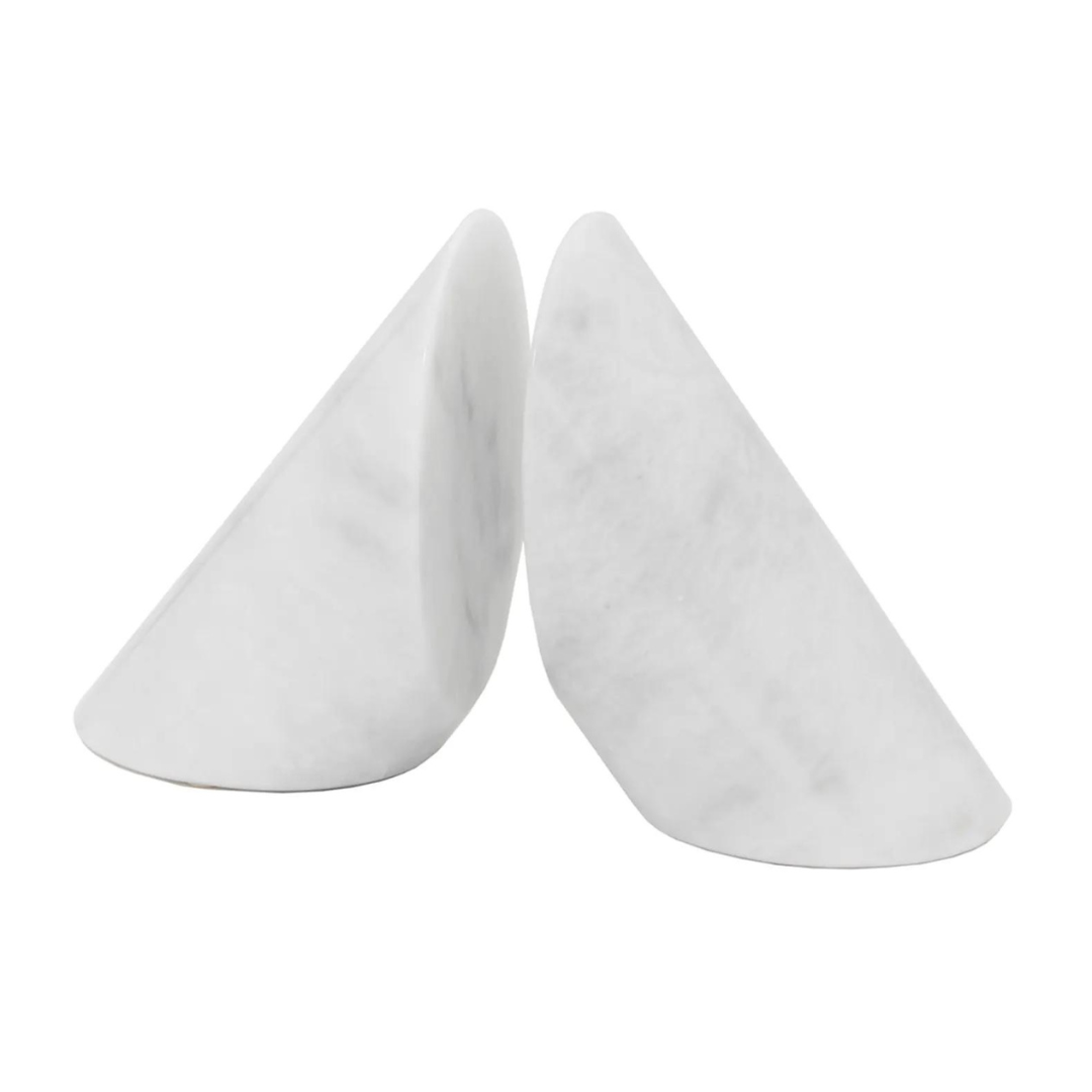 The Coronet Marble Bookends Pearl by Designs by Marble Crafter feature two white marble bookends with smooth, angled surfaces, forming a modern geometric shape—elegant decor crafted from natural stone.