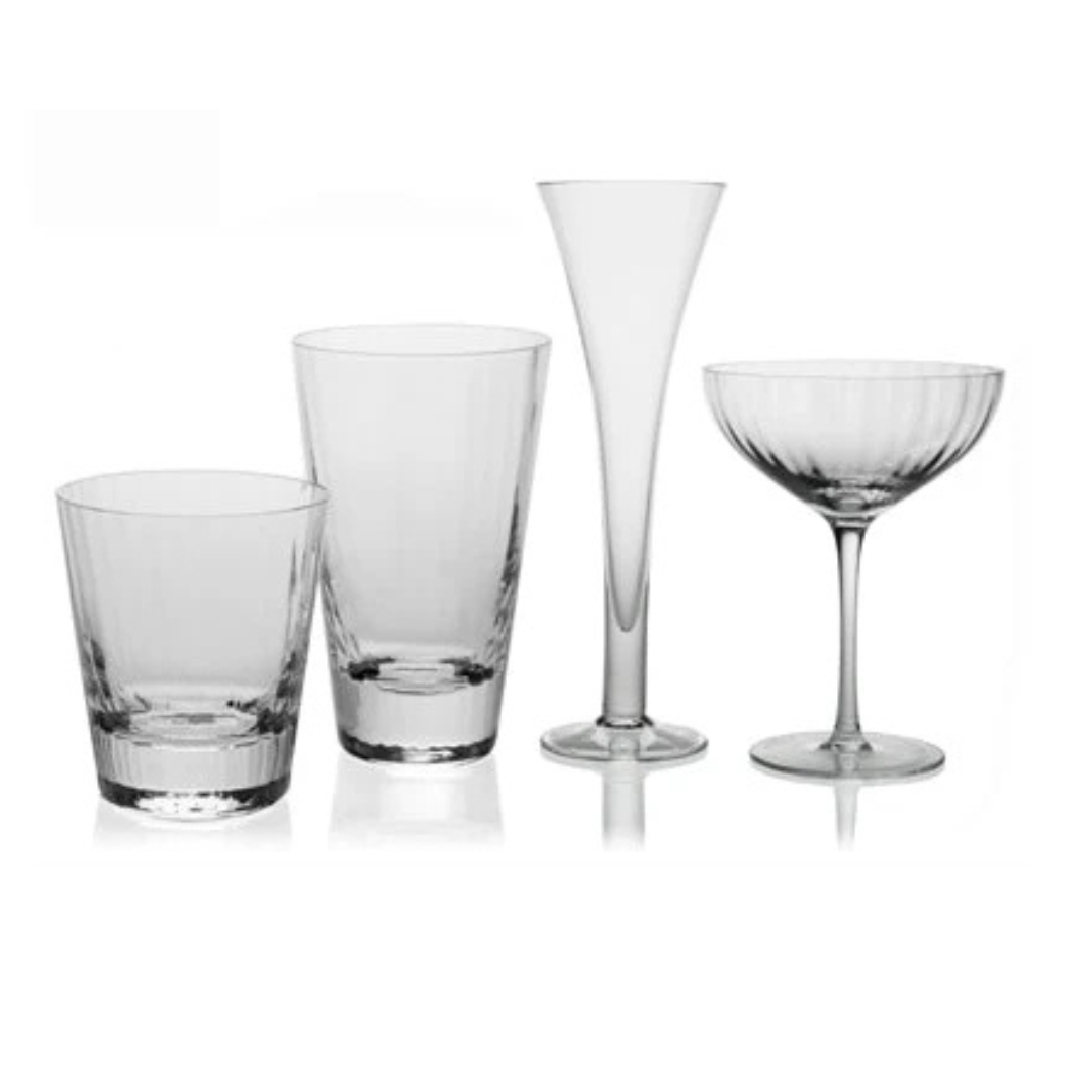 Four styles of Corinne Drinkware by William Yeoward—a tumbler, highball, tall flute, and coupe—are arranged side by side on a white background, highlighting the clear contemporary optic effect design.