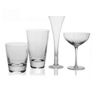 Four styles of Corinne Drinkware by William Yeoward—a tumbler, highball, tall flute, and coupe—are arranged side by side on a white background, highlighting the clear contemporary optic effect design.