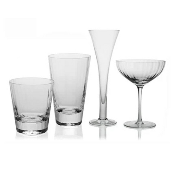 Four styles of Corinne Drinkware by William Yeoward—a tumbler, highball, tall flute, and coupe—are arranged side by side on a white background, highlighting the clear contemporary optic effect design.