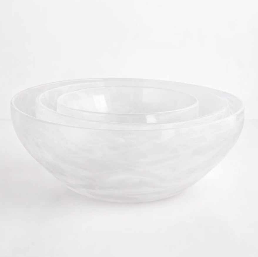 Three clear, handcrafted Gary Bodker Nesting Bowl White Cotton bowls are stacked on a plain white surface, highlighting the elegance of this stylish set.