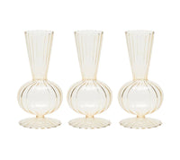 The Kim Seybert Tess Bud Vase Set of 4 in Champagne features identical translucent vases with round bases, fluted bottoms, narrow necks, and vertical ribbed lines, arranged side by side on a white background.